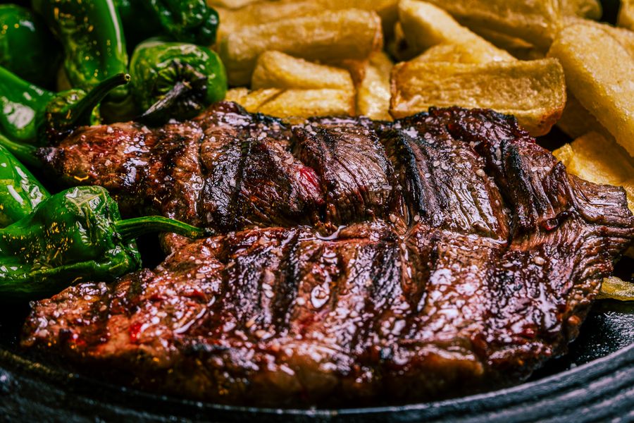 Bistec a la parrilla con pimientos verdes asados y papas crujientes